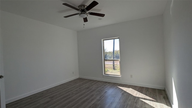 empty room with a ceiling fan, dark wood-style flooring, and baseboards