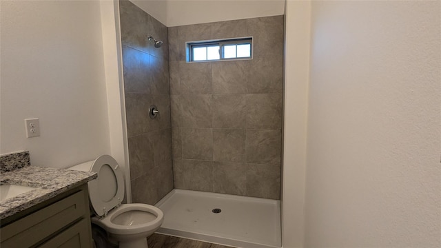 full bath with toilet, a stall shower, wood finished floors, and vanity