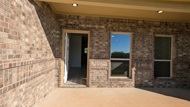 view of exterior entry featuring brick siding