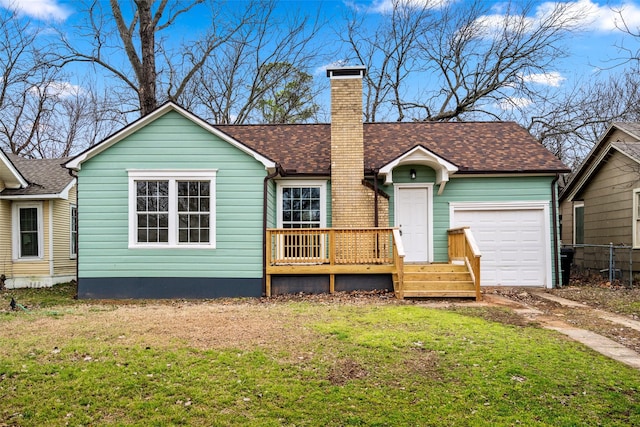 rear view of property with a shingled roof, a yard, a chimney, and an attached garage