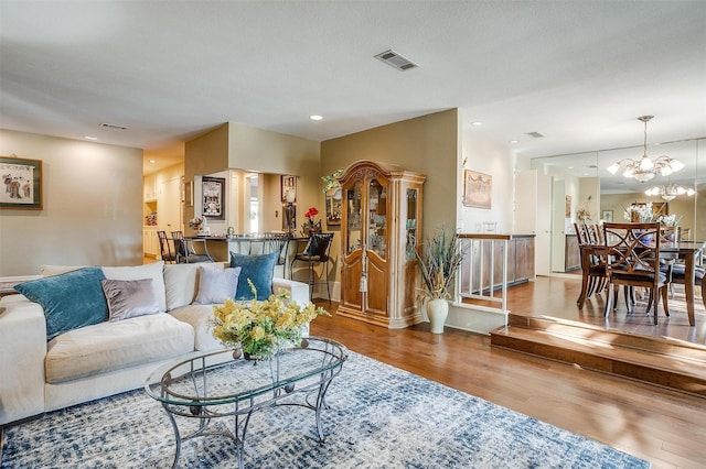 living room featuring a notable chandelier, visible vents, wood finished floors, and recessed lighting