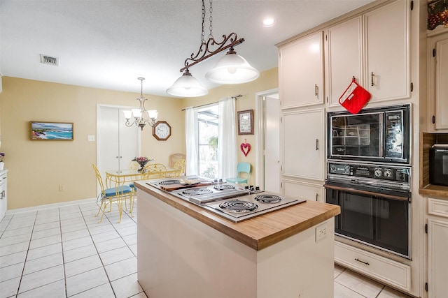 kitchen with light tile patterned floors, visible vents, wood counters, hanging light fixtures, and black appliances