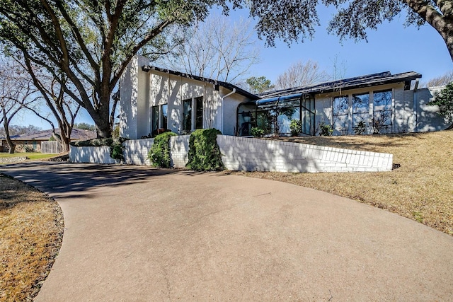 view of front facade featuring brick siding and fence