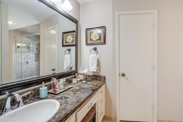 bathroom with a shower stall and vanity