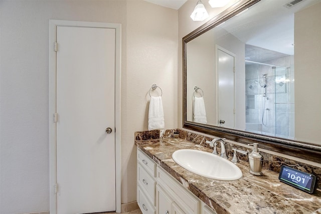 bathroom featuring visible vents, a shower stall, and vanity