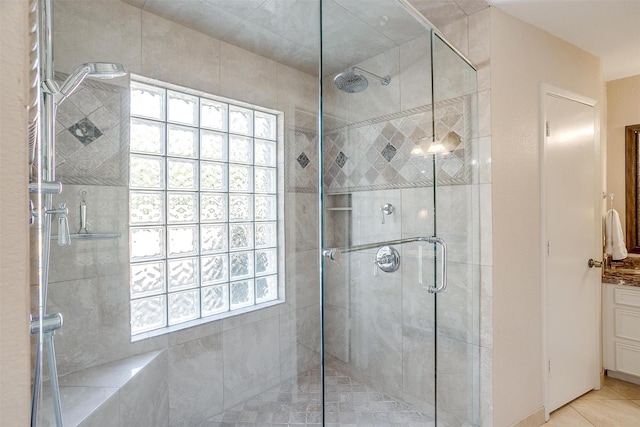 full bath with plenty of natural light, a shower stall, and tile patterned floors