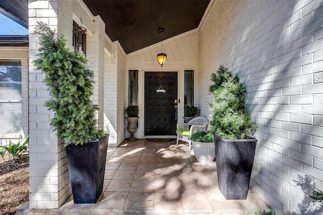 property entrance with covered porch and brick siding