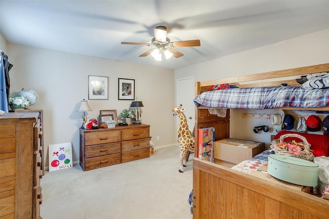 bedroom featuring light carpet, a ceiling fan, and baseboards