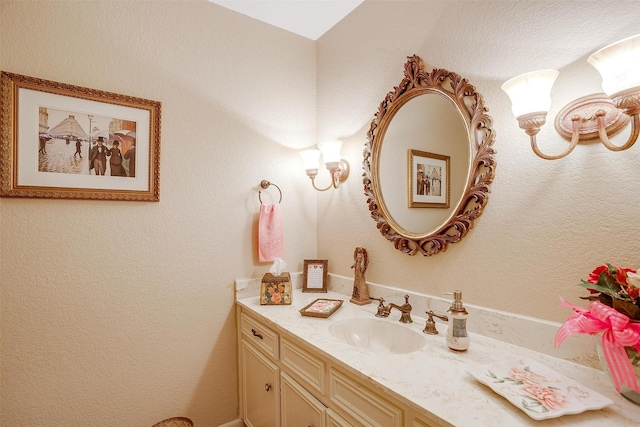 bathroom with a textured wall and vanity