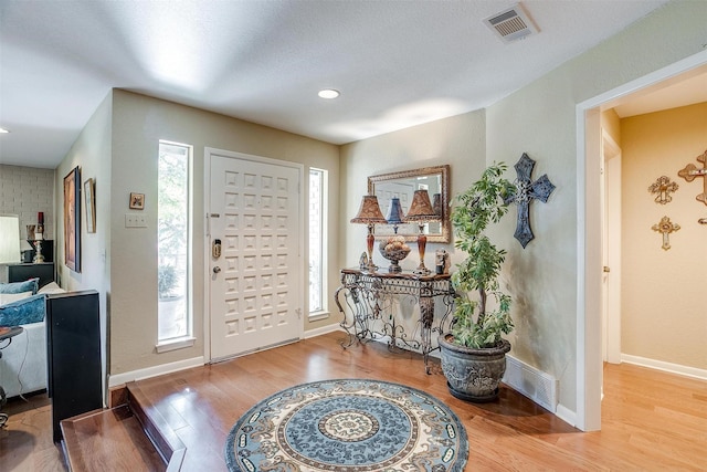 foyer entrance featuring recessed lighting, wood finished floors, visible vents, and baseboards