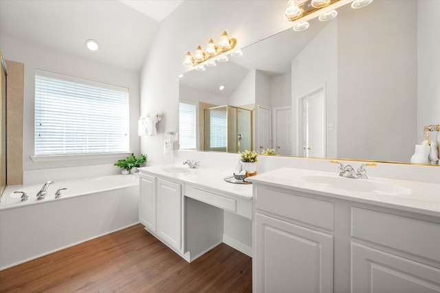 full bath with double vanity, a shower stall, vaulted ceiling, and a sink