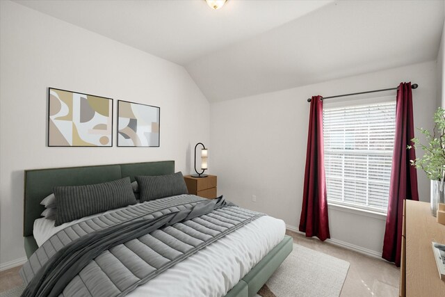 empty room with light carpet, baseboards, and vaulted ceiling