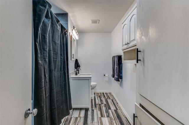 full bathroom with baseboards, visible vents, toilet, wood finished floors, and curtained shower