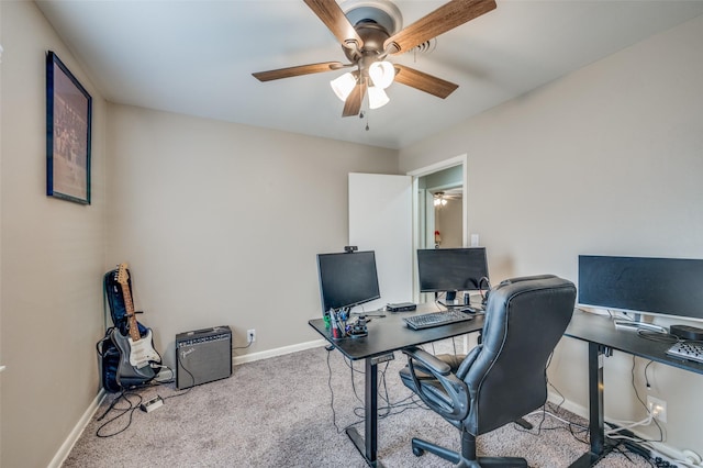 carpeted office space with ceiling fan and baseboards