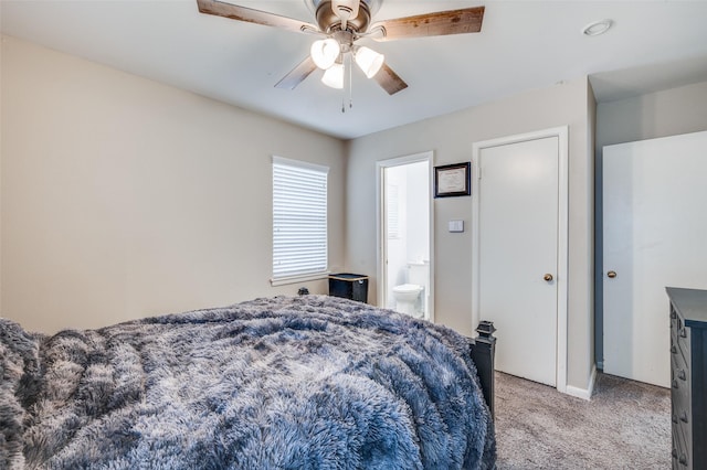 bedroom with light carpet, ensuite bath, and a ceiling fan