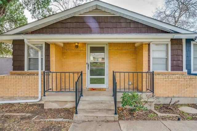 bungalow-style house featuring covered porch and brick siding