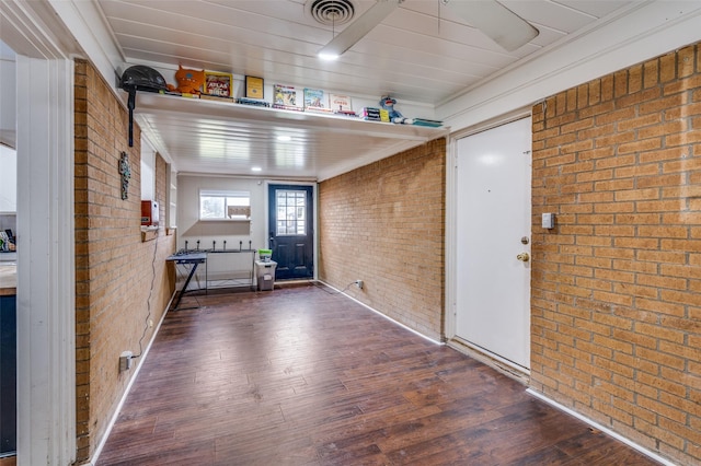 foyer featuring visible vents, brick wall, and wood finished floors