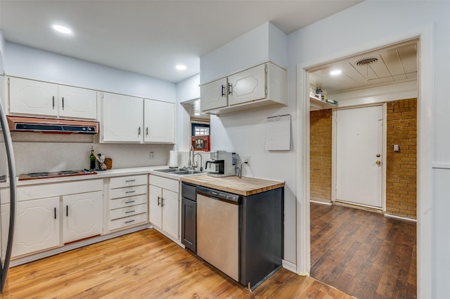 kitchen featuring white cabinets, light wood-style flooring, stainless steel dishwasher, under cabinet range hood, and a sink