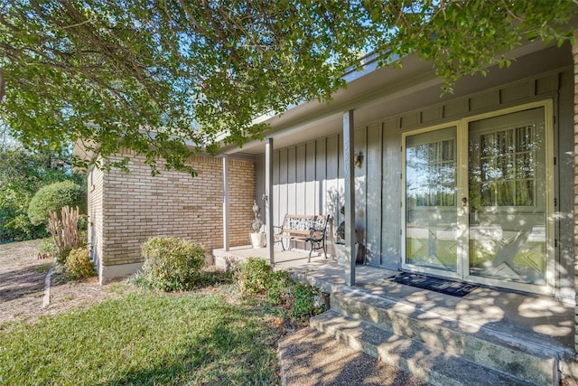 view of exterior entry with brick siding