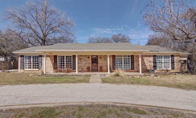 ranch-style home featuring covered porch, an attached carport, french doors, and brick siding