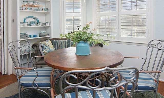 dining room with built in shelves and wood finished floors