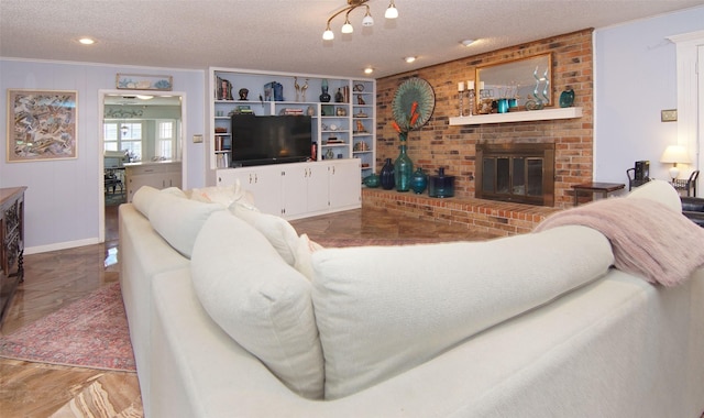 living area featuring a textured ceiling, marble finish floor, a brick fireplace, and built in features