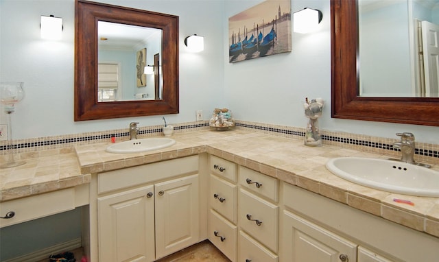 full bath featuring double vanity, ornamental molding, and a sink