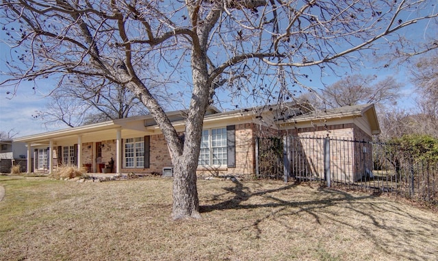 ranch-style home with brick siding, a front lawn, and fence