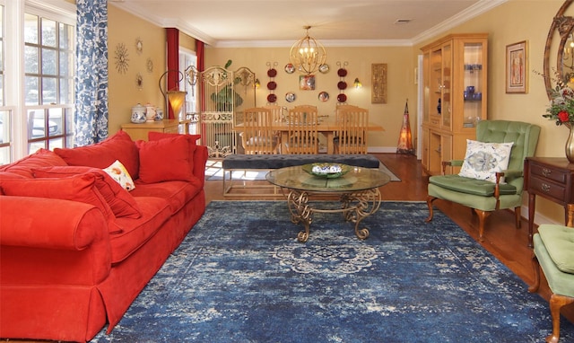 living area featuring ornamental molding, a notable chandelier, and wood finished floors