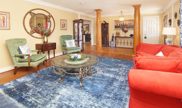 living room featuring decorative columns, baseboards, crown molding, and wood finished floors