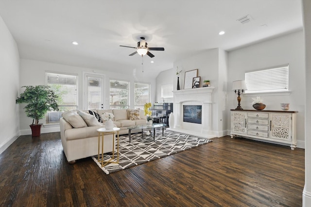 living room with a glass covered fireplace, visible vents, wood finished floors, and recessed lighting