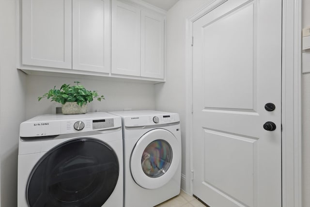 clothes washing area featuring light tile patterned floors, cabinet space, and independent washer and dryer