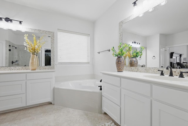 full bathroom featuring a stall shower, vanity, and a garden tub