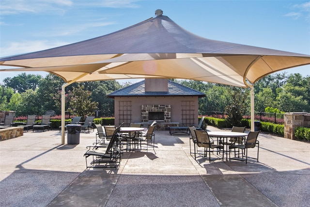 view of patio / terrace with an outdoor stone fireplace and fence