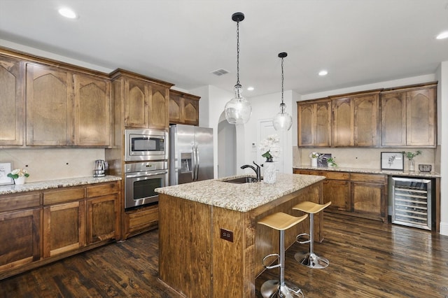 kitchen with visible vents, dark wood-type flooring, a center island with sink, wine cooler, and appliances with stainless steel finishes