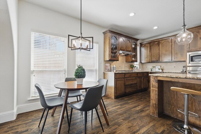 dining area with a notable chandelier, recessed lighting, dark wood-style floors, and baseboards