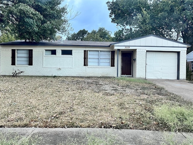 ranch-style home with board and batten siding, concrete driveway, brick siding, and a garage