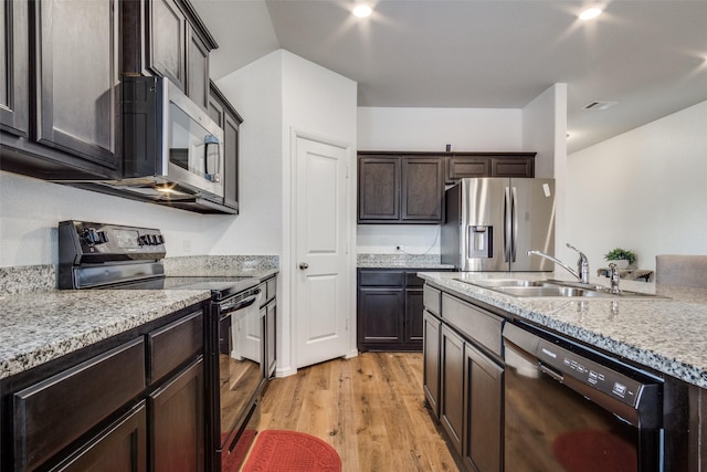 kitchen featuring visible vents, light wood-style floors, a sink, dark brown cabinets, and black appliances