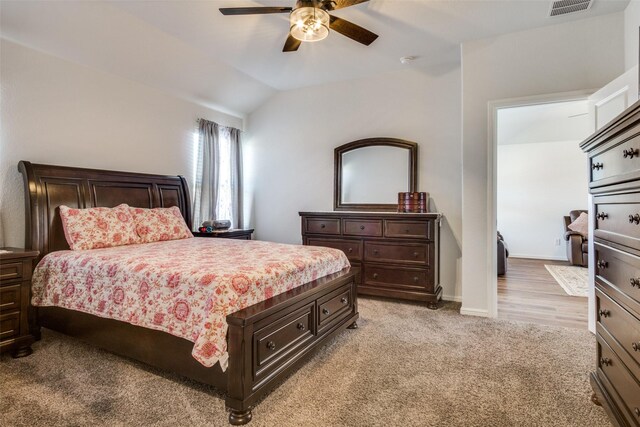 bedroom with light carpet, a ceiling fan, visible vents, vaulted ceiling, and baseboards