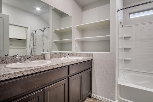 bathroom with double vanity, shower / tub combo, and a sink