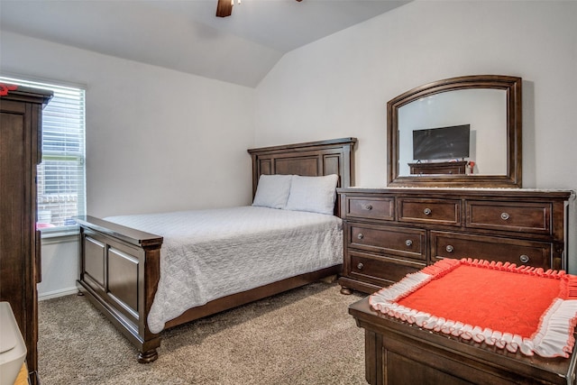 bedroom with light colored carpet, vaulted ceiling, baseboards, and ceiling fan