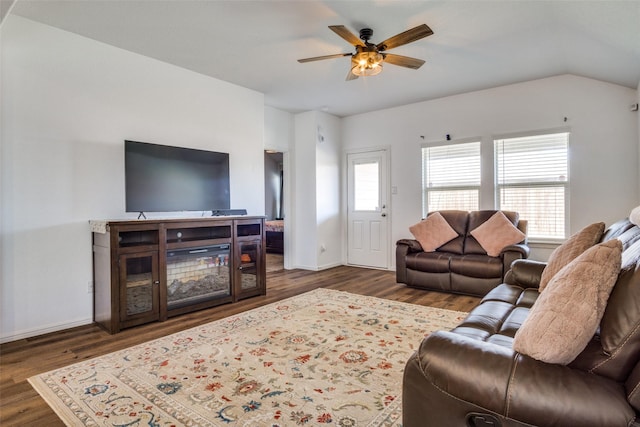 living area with lofted ceiling, ceiling fan, baseboards, and wood finished floors