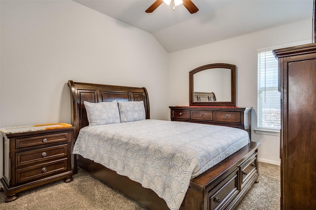 bedroom with ceiling fan, baseboards, vaulted ceiling, and light colored carpet