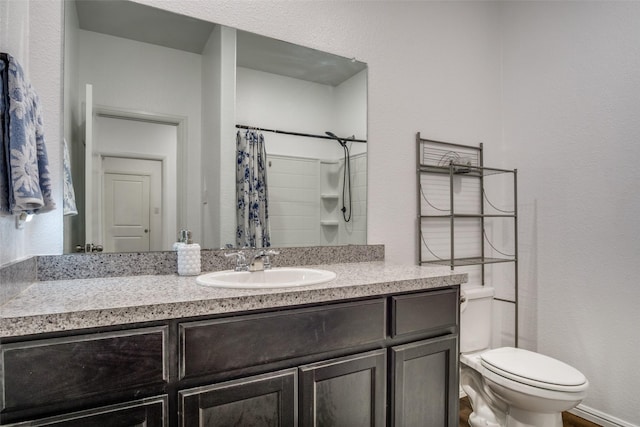 bathroom with toilet, curtained shower, and vanity