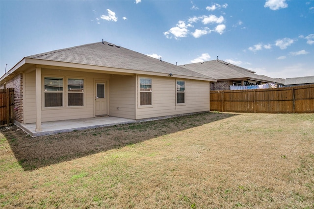 back of property with a patio, a lawn, and fence