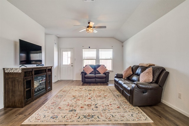 living area featuring vaulted ceiling, ceiling fan, wood finished floors, and baseboards