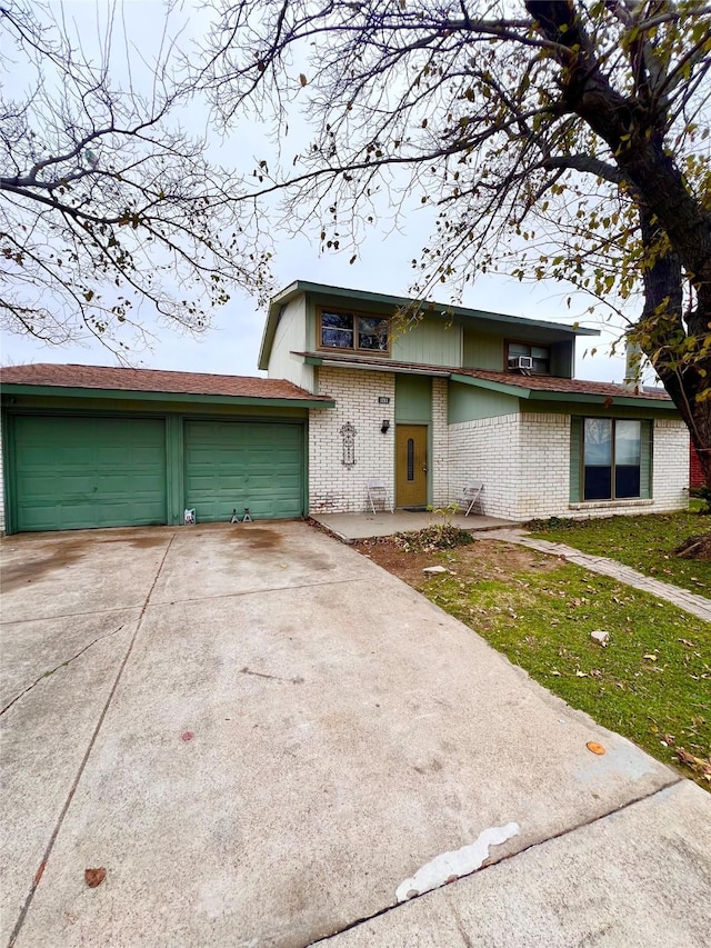 view of front of house featuring driveway, a garage, and brick siding