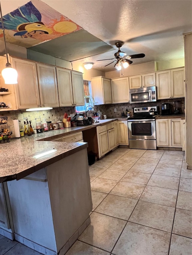 kitchen with a peninsula, tasteful backsplash, light brown cabinets, and appliances with stainless steel finishes