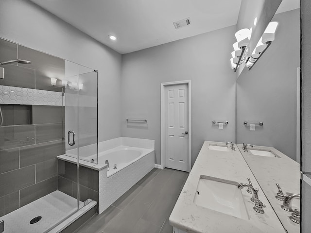 bathroom with a garden tub, double vanity, a sink, and visible vents