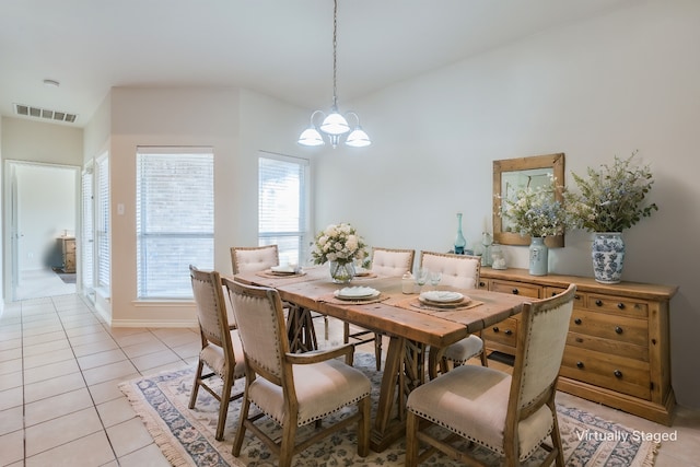 dining room featuring visible vents, an inviting chandelier, light tile patterned flooring, baseboards, and vaulted ceiling